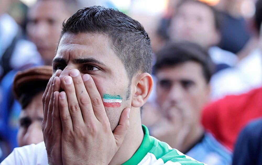 An Iran soccer fan watches his team loose 1-0 to Argentina on TV at a bar near Minerao Stadium, where the game takes place in Belo Horizonte, Brazil.