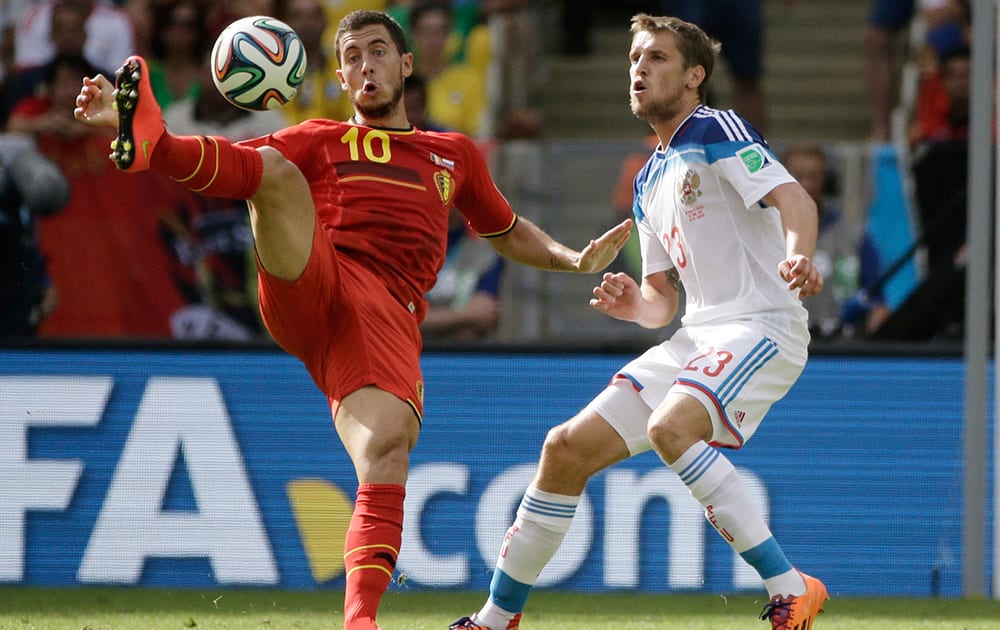 Belgium's Eden Hazard, left, is challenged by Russia's Dmitry Kombarov during the group H World Cup soccer match between Belgium and Russia at the Maracana Stadium in Rio de Janeiro, Brazil.