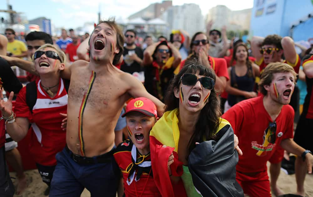 Soccer fans react as they watch a live broadcast of the group H World Cup match between Belgium and Russia inside the FIFA Fan Fest area on Copacabana beach, in Rio de Janeiro, Brazil.