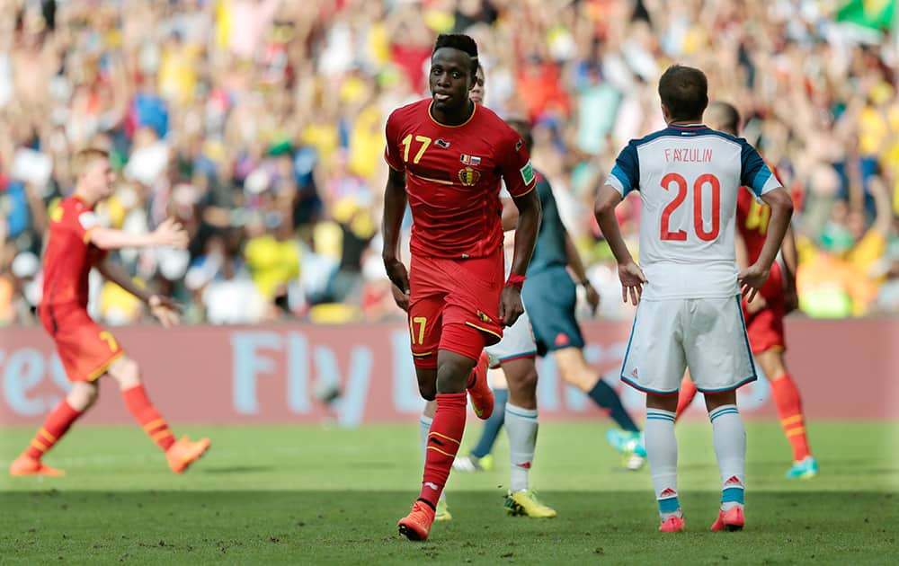 Belgium's Divock Origi, center, reacts near Russia's Viktor Fayzulin, right, after Origi scored the opening goal during the group H World Cup soccer match between Belgium and Russia at the Maracana stadium in Rio de Janeiro, Brazil.