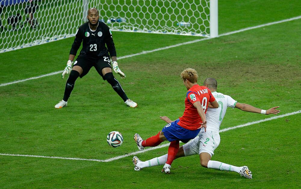 South Korea's Son Heung-min, center, shoots and scores his side's first goal past Algeria's goalkeeper Rais M'Bolhi during the group H World Cup soccer match between South Korea and Algeria at the Estadio Beira-Rio in Porto Alegre, Brazil.