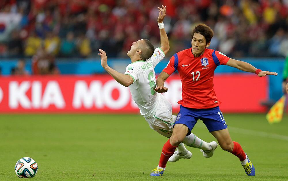 Algeria's Djamel Mesbah is fouled by South Korea's Lee Yong during the group H World Cup soccer match between South Korea and Algeria at the Estadio Beira-Rio in Porto Alegre, Brazil.