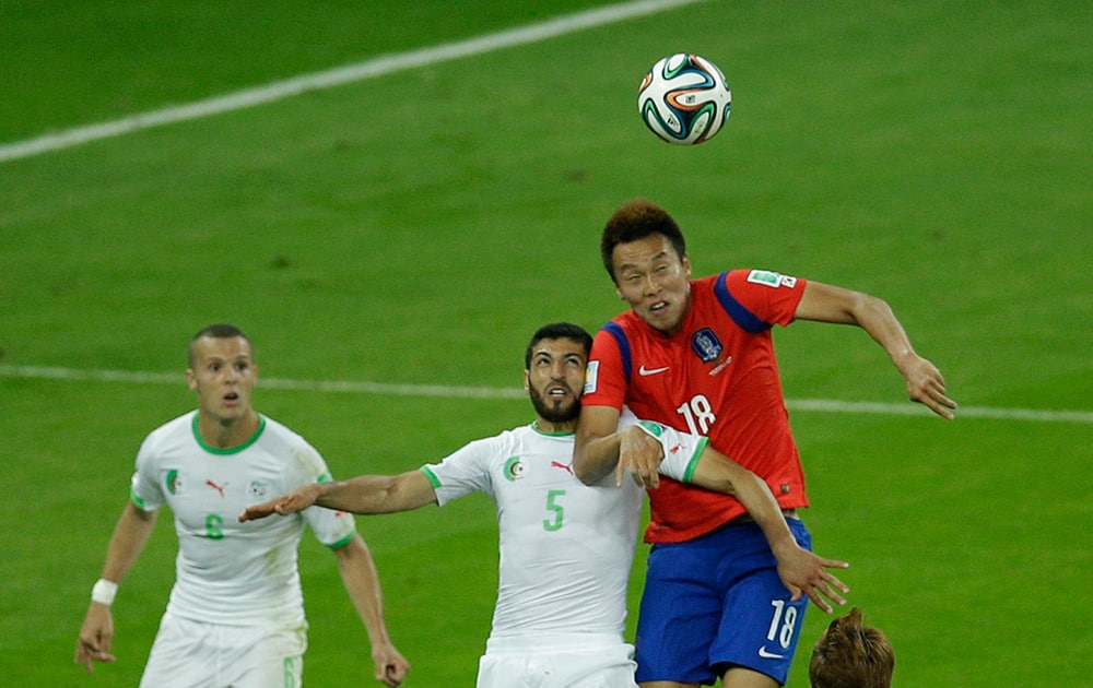 Algeria's Medhi Lacen looks on as South Korea's Kim Shin-wook and Algeria's Rafik Halliche jump to head the ball during the group H World Cup soccer match between South Korea and Algeria at the Estadio Beira-Rio in Porto Alegre, Brazil.