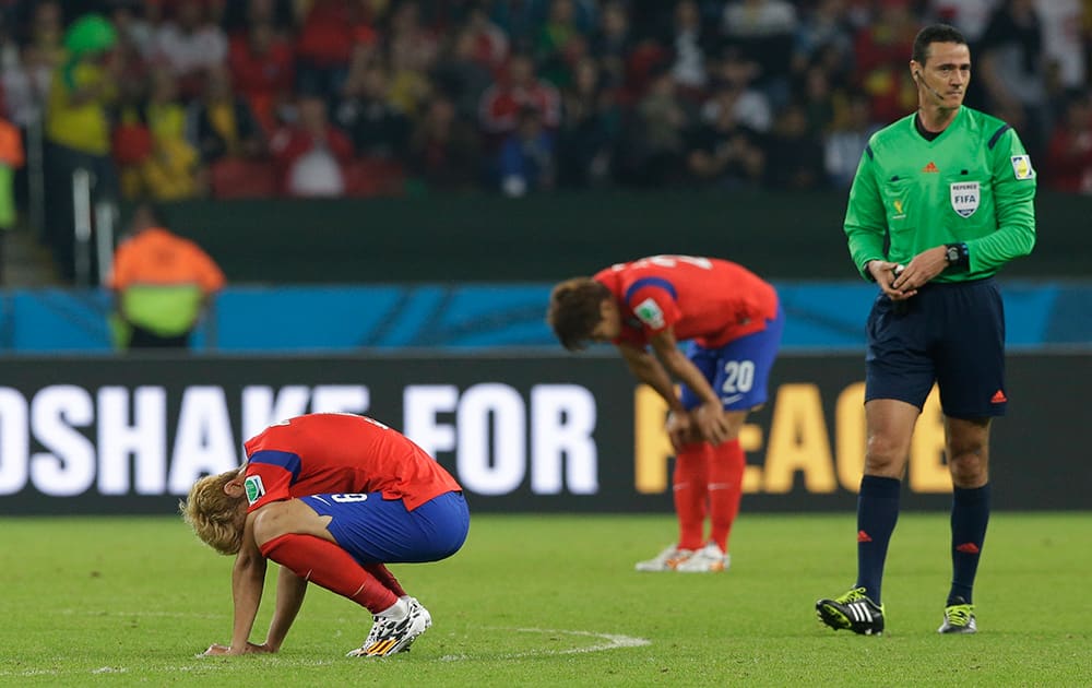 South Korea's Son Heung-min and Hong Jeong-ho stay on the pitch after Algeria's 4-2 victory over South Korea during the group H World Cup soccer match between South Korea and Algeria at the Estadio Beira-Rio in Porto Alegre, Brazil.