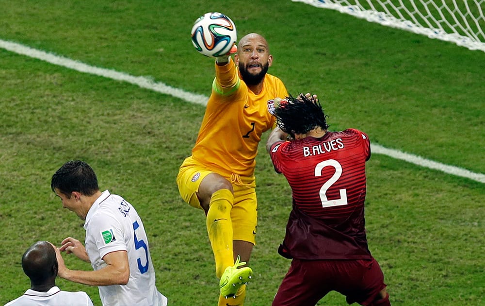 United States' goalkeeper Tim Howard reaches a ball ahead of Portugal's Bruno Alves during the group G World Cup soccer match between the USA and Portugal at the Arena da Amazonia in Manaus, Brazil.