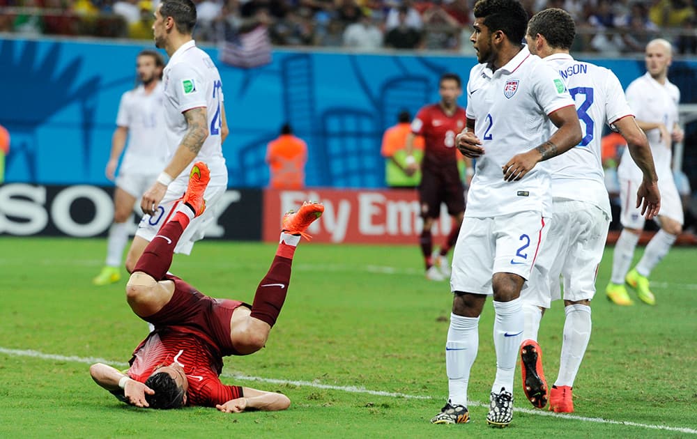 Portugal's Cristiano Ronald, lower left, takes a tumble during the group G World Cup soccer match between the USA and Portugal at the Arena da Amazonia in Manaus, Brazil.