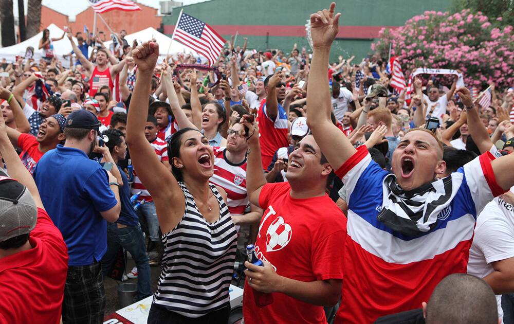 USA fans react to USA's second goal against Portugal during the Houston Dynamo's viewing party of the group G World Cup soccer match between on the street at Lucky’s Pub in Houston, Texas.