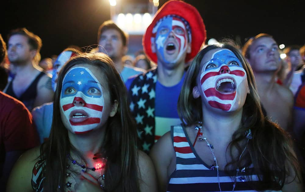 Fans with their faces painted with the U.S. national soccer team's colors, watch a live telecast of the group G World Cup match between United States and Portugal, inside the FIFA Fan Fest area on Copacabana beach, in Rio de Janeiro, Brazil.