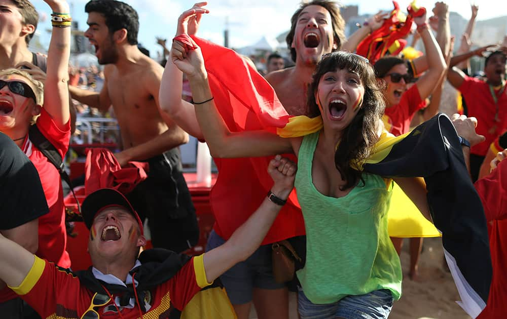 Soccer fans celebrate the goal scored by Belgium as they watch a live broadcast of the group H World Cup match between Belgium and Russia inside the FIFA Fan Fest area on Copacabana beach, in Rio de Janeiro, Brazil.