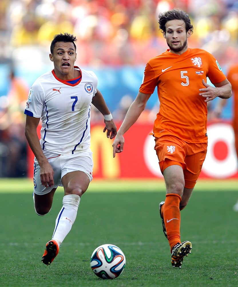 Netherlands' Daley Blind (5) chases Chile's Alexis Sanchez (7) as he attacks during the group B World Cup soccer match between the Netherlands and Chile at the Itaquerao Stadium in Sao Paulo, Brazil.