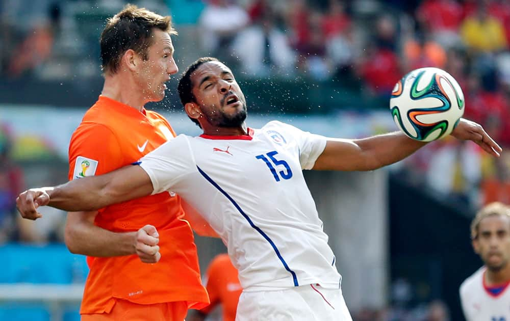 Netherlands' Stefan de Vrij heads the ball past Chile's Jean Beausejour during the group B World Cup soccer match between the Netherlands and Chile at the Itaquerao Stadium in Sao Paulo, Brazil.