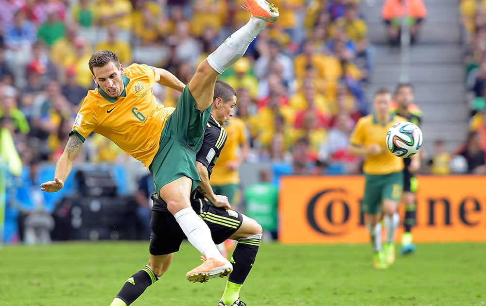 Australia's Matthew Spiranovic and Spain's Fernando Torres fight for the ball during the group B World Cup soccer match between Australia and Spain at the Arena da Baixada in Curitiba, Brazil.