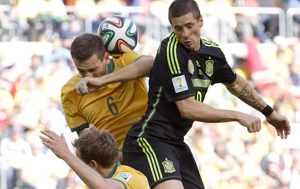 Spain's Fernando Torres goes for a header with Australia's Matthew Spiranovic during the group B World Cup soccer match between Australia and Spain at the Arena da Baixada in Curitiba, Brazil.