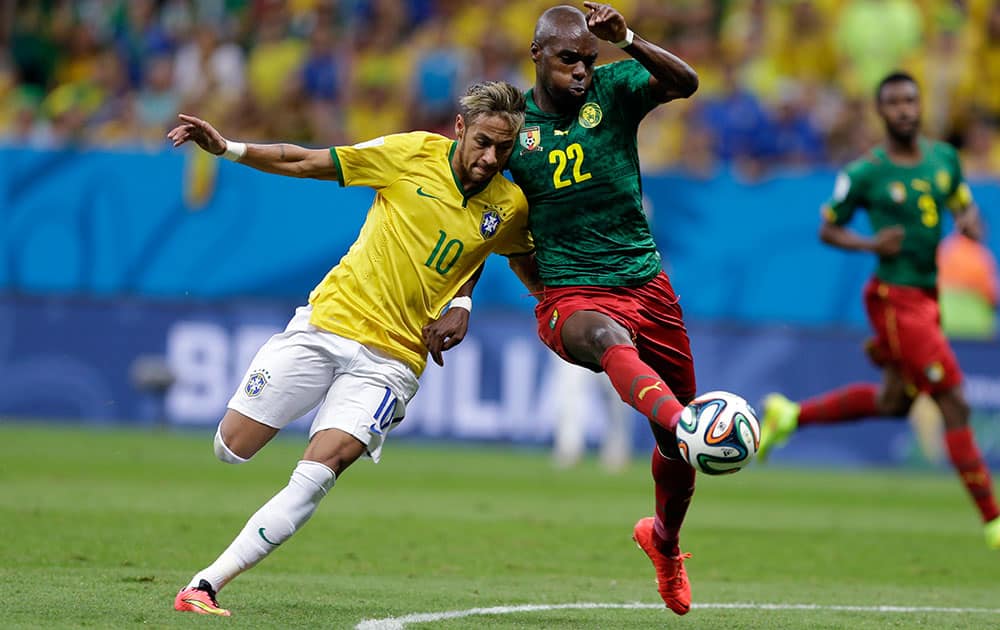 Brazil's Neymar, left, and Cameroon's Allan Nyom challenge for the ball during the group A World Cup soccer match between Cameroon and Brazil at the Estadio Nacional in Brasilia, Brazil.