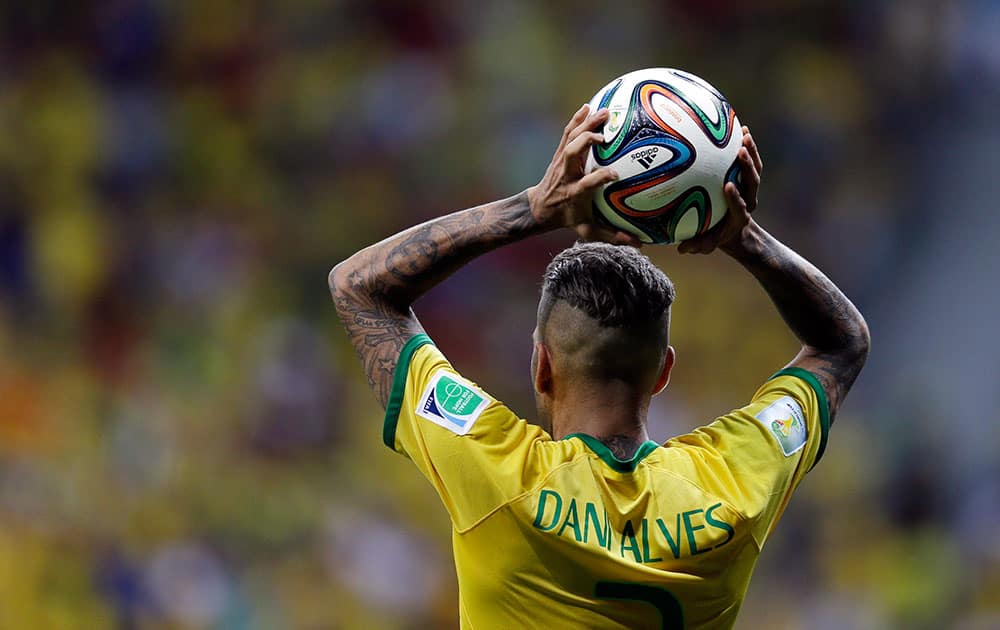 Brazil's Dani Alves throws the ball from the sidelines during the group A World Cup soccer match between Cameroon and Brazil at the Estadio Nacional in Brasilia, Brazil.