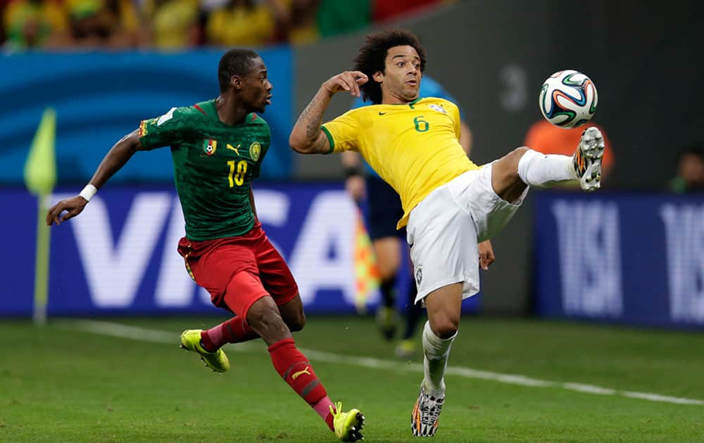 Brazil's Marcelo, right, challenges for the ball with Cameroon's Vincent Aboubakar during the group A World Cup soccer match between Cameroon and Brazil at the Estadio Nacional in Brasilia, Brazil.