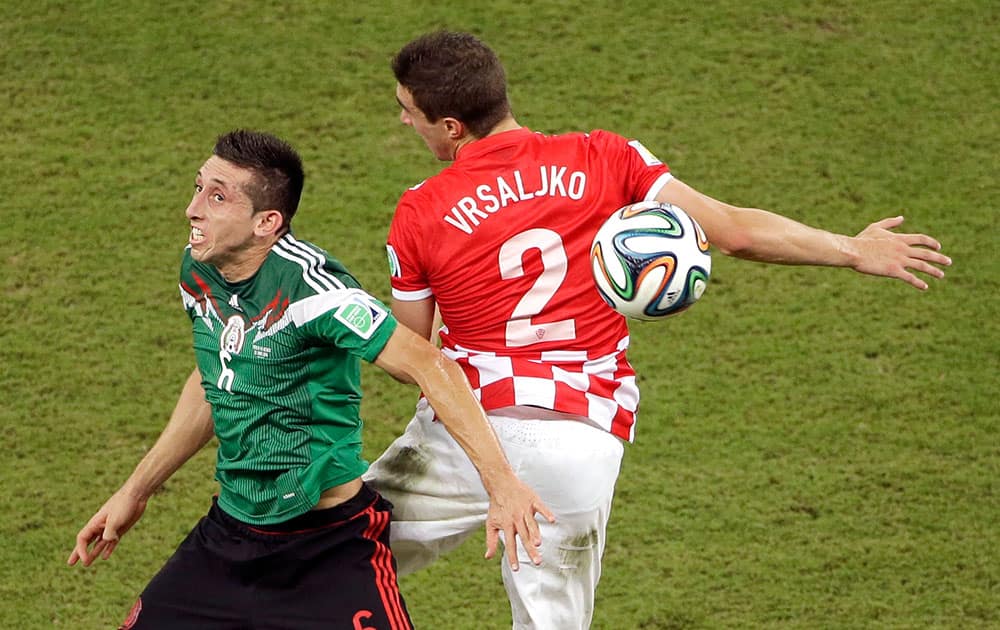 Mexico's Hector Herrera and Croatia's Sime Vrsaljko battle for the ball during the group A World Cup soccer match between Croatia and Mexico at the Arena Pernambuco in Recife, Brazil.