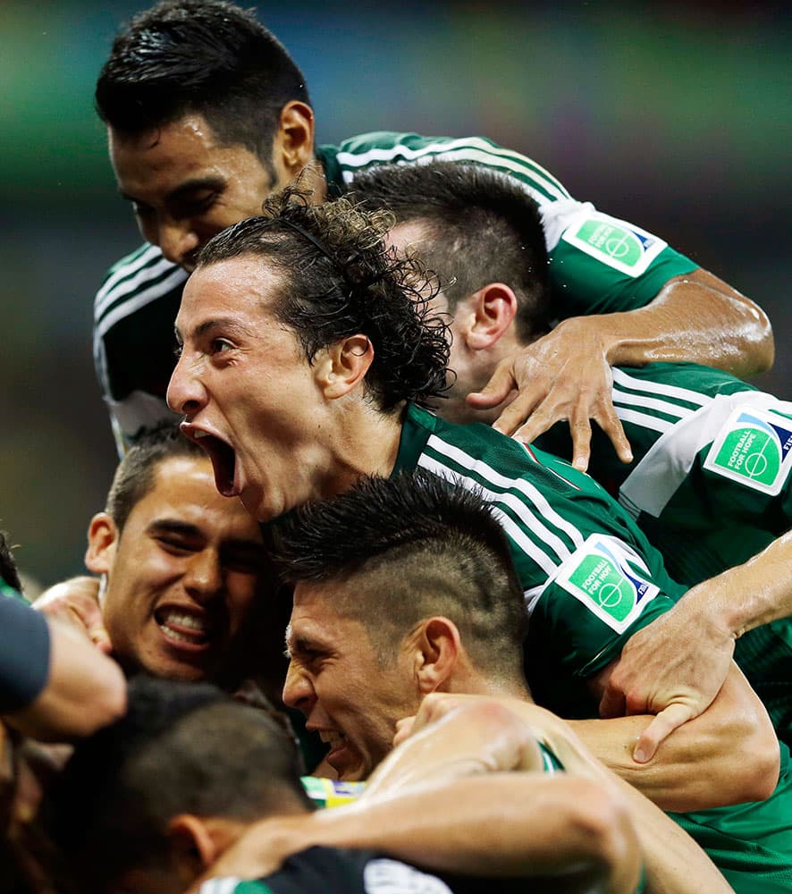 Mexico's Andres Guardado celebrates with teammates after Mexico's Rafael Marquez scored his team's first goal during the group A World Cup soccer match between Croatia and Mexico at the Arena Pernambuco in Recife, Brazil.