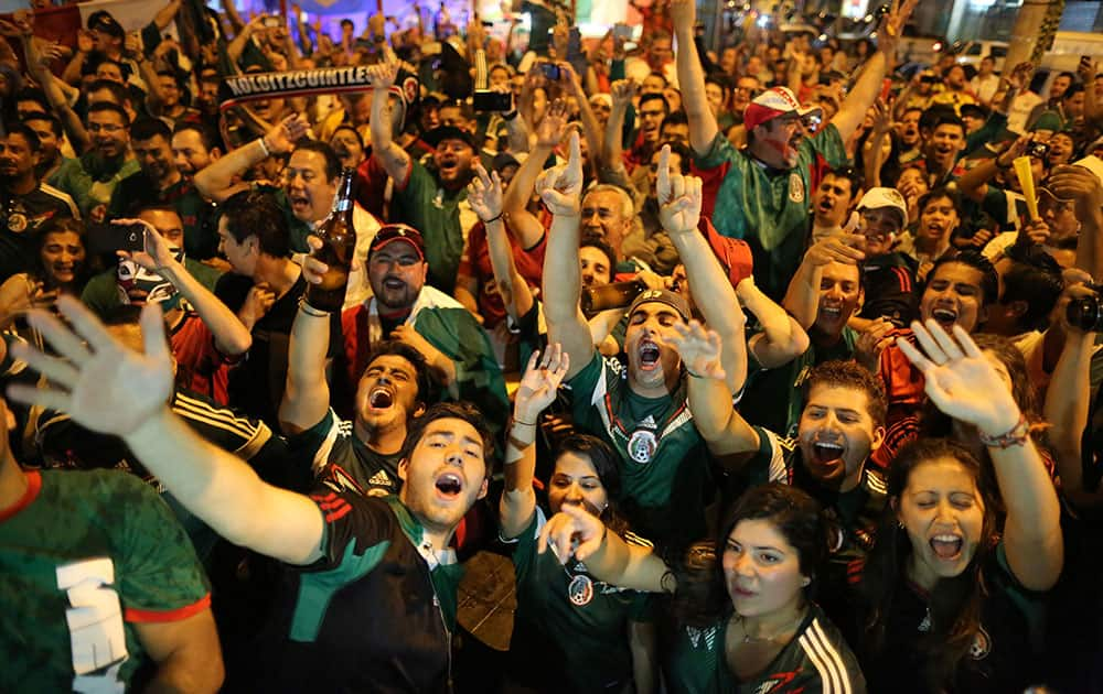 Mexico soccer fans celebrate a goal scored by their team on a street of Copacabana, in Rio de Janeiro, Brazil.