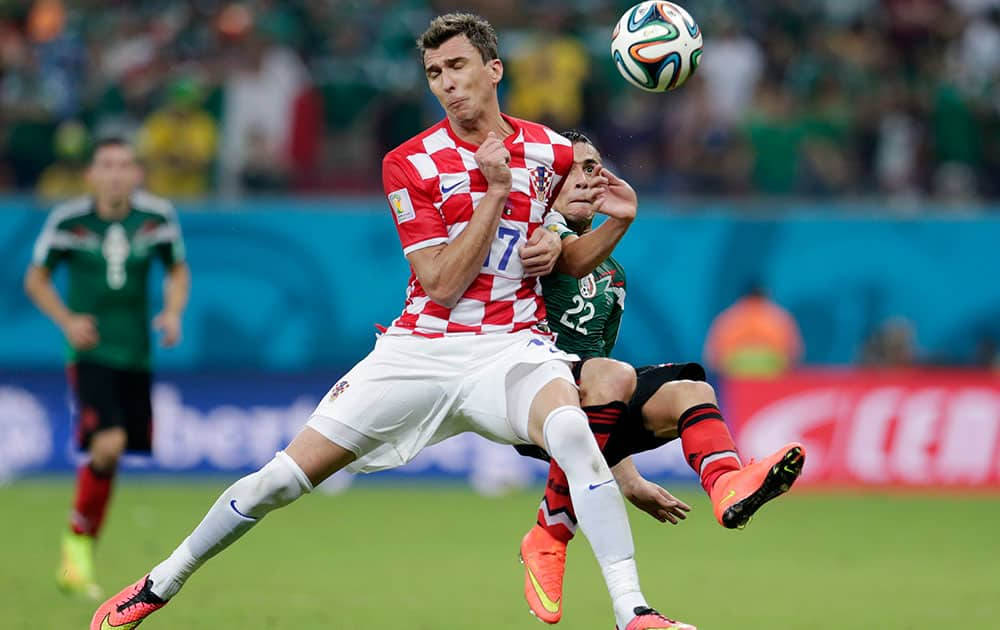 Croatia's Mario Mandzukic, left, and Mexico's Paul Aguilar battle for the ball during the group A World Cup soccer match between Croatia and Mexico at the Arena Pernambuco in Recife, Brazil.