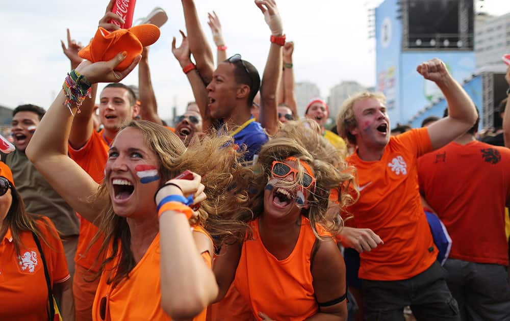 Soccer fans, decked out in orange, the Netherlands' national color, celebrate the second goal scored by Memphis Depay, while watching a live broadcast of the group B World Cup match between Chile and Netherlands, inside the FIFA Fan Fest area on Copacabana beach, in Rio de Janeiro, Brazil.