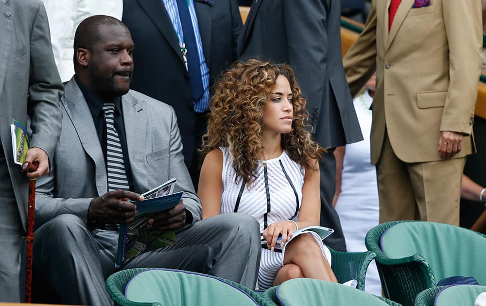 US retired basketball player Shaquille O'Neal, left, watches a play on centre court during the first day at the All England Lawn Tennis Championships in Wimbledon, London.