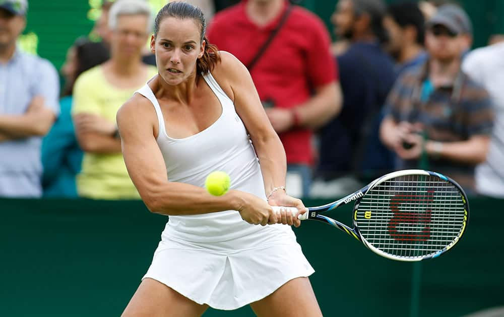 Jarmila Gajdosova of Australia plays a return to Stefanie Voegele of Switzerland during their first round match at the All England Lawn Tennis Championships in Wimbledon.