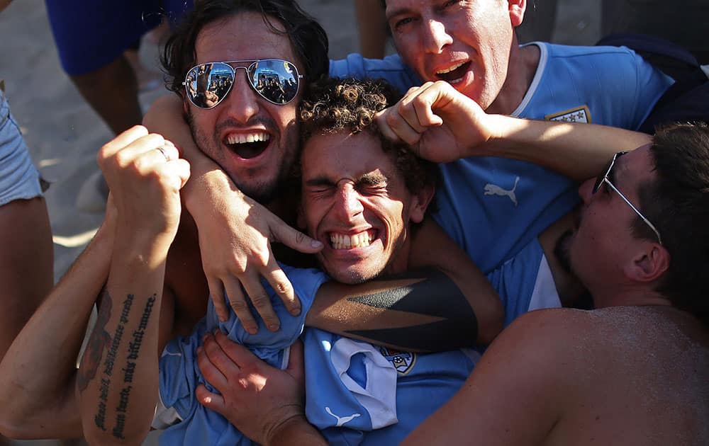 Uruguay soccer fans celebrate their team's 1-0 victory over Italy at a World Cup game after watching a live telecast inside the FIFA Fan Fest area on Copacabana beach in Rio de Janeiro, Brazil.