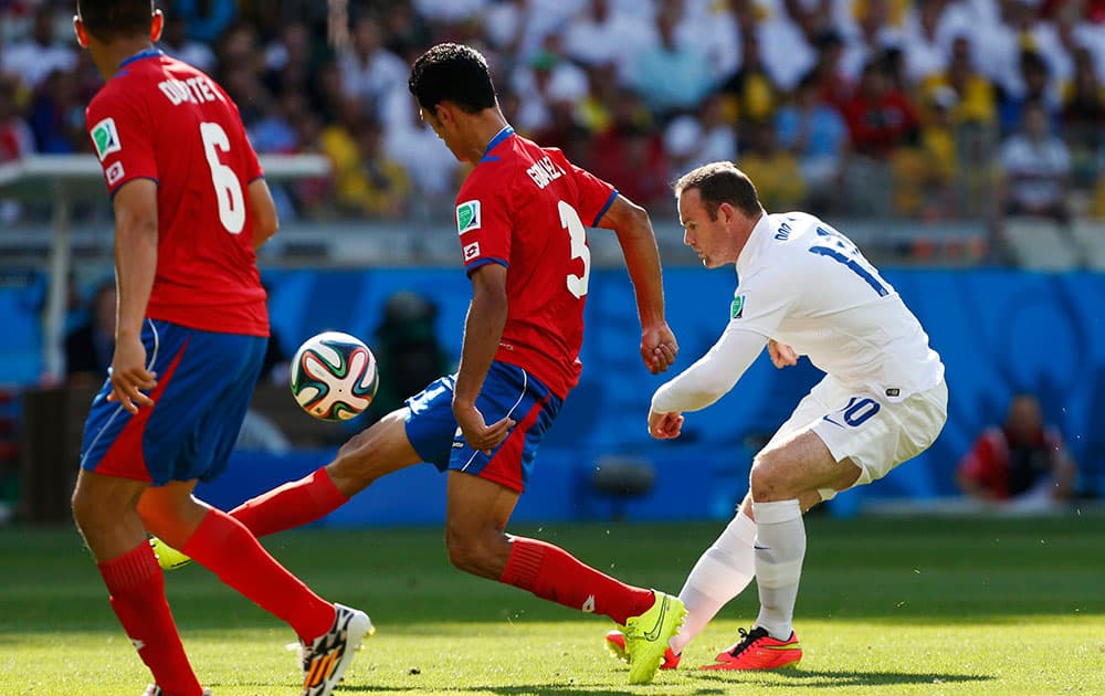 England's Wayne Rooney, right, tries to chip the ball in during the group D World Cup soccer match between Costa Rica and England at the Mineirao Stadium in Belo Horizonte, Brazil.