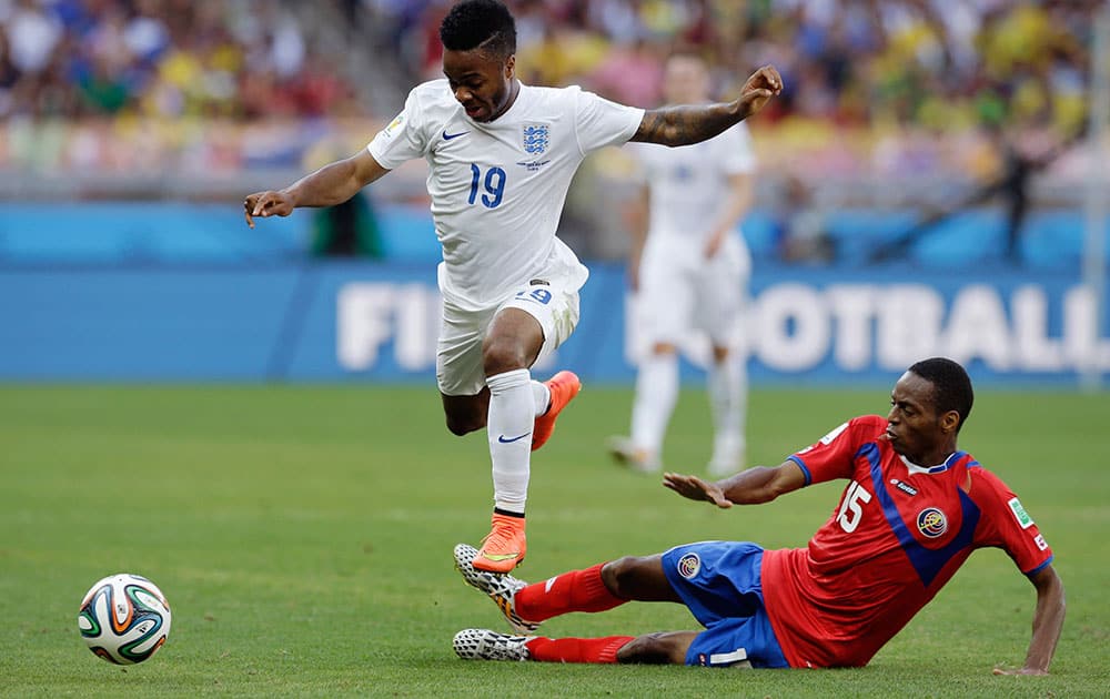 England's Raheem Sterling, top, jumps over the tackle of Costa Rica's Junior Diaz during the group D World Cup soccer match between Costa Rica and England at the Mineirao Stadium in Belo Horizonte, Brazil.