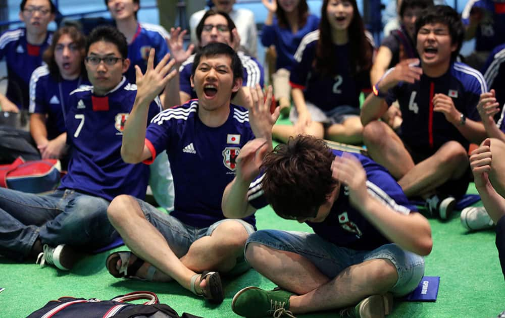 Japanese soccer fans are dejected after watching a live broadcasting of the group C World Cup soccer match between Japan and Colombia at a public viewing venue in Tokyo.