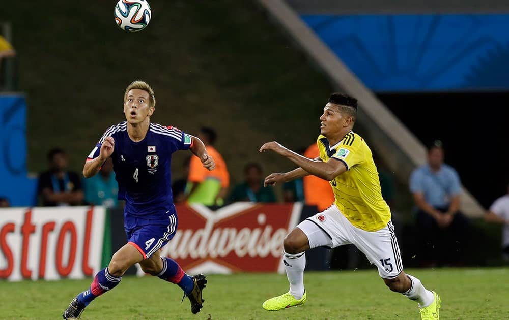 Japan's Keisuke Honda, left, and Colombia's Alexander Mejia battle for the ball during the group C World Cup soccer match between Japan and Colombia at the Arena Pantanal in Cuiaba, Brazil.