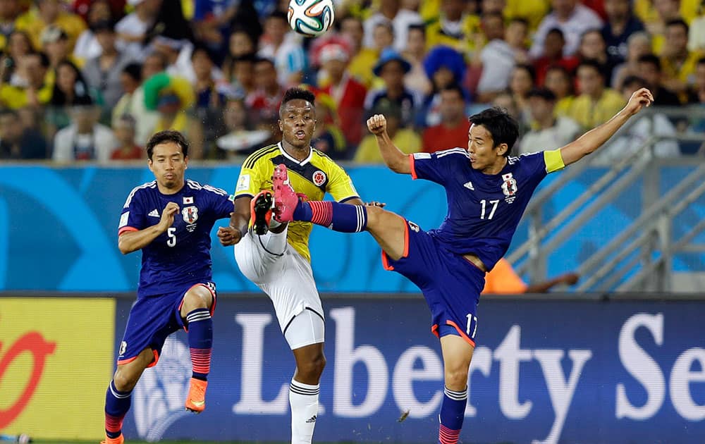 Japan's Yuto Nagatomo (5) and Japan's Makoto Hasebe (17) challenge Colombia's Carlos Carbonero during the group C World Cup soccer match between Japan and Colombia at the Arena Pantanal in Cuiaba, Brazil.