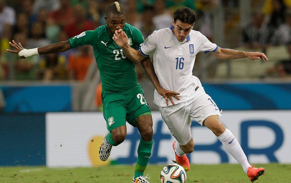 Ivory Coast's Serey Die, left, and Greece's Lazaros Christodoulopoulos challenge for the ball during the group C World Cup soccer match between Greece and Ivory Coast at the Arena Castelao in Fortaleza, Brazil.