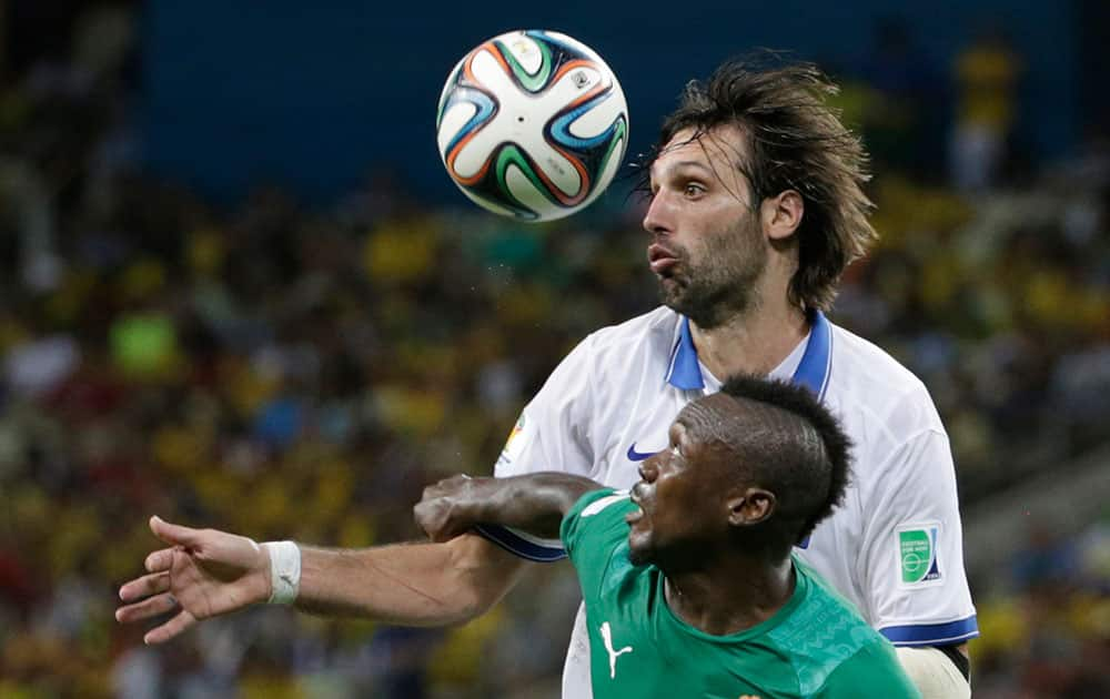 Ivory Coast's Arthur Boka, front, and Greece's Giorgos Samaras challenge for the ball during the group C World Cup soccer match between Greece and Ivory Coast at the Arena Castelao in Fortaleza, Brazil.