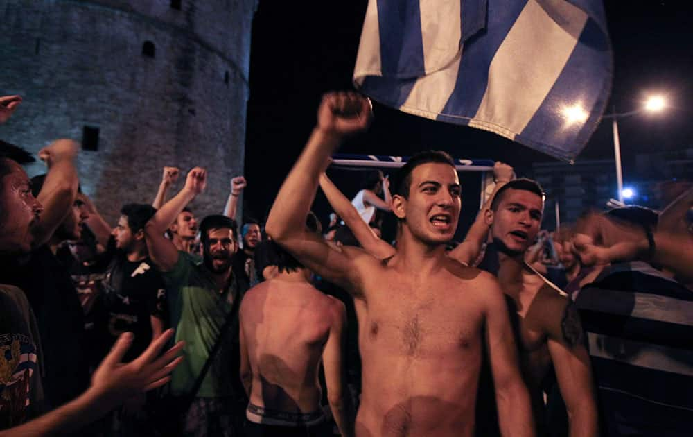 Greece soccer supporters celebrate their team's win in a World Cup soccer match in front of city's landmark of White Tower, in the northern Greek port of Thessaloniki.