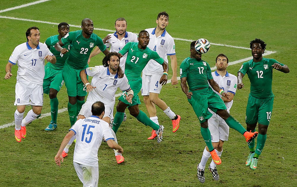 Ivory Coast's Serge Aurier (17) heads the ball under pressure in the second half during the group C World Cup soccer match between Greece and Ivory Coast at the Arena Castelao in Fortaleza, Brazil.