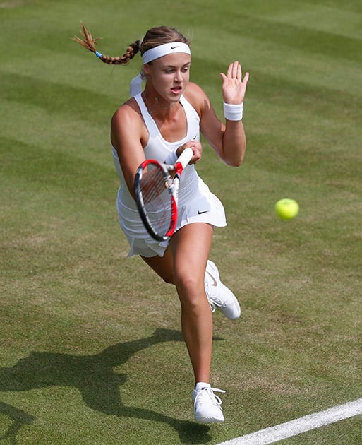 Anna Schmiedlova of Slovakia plays a return to Alize Cornet of France during their first round match at the All England Lawn Tennis Championships in Wimbledon.