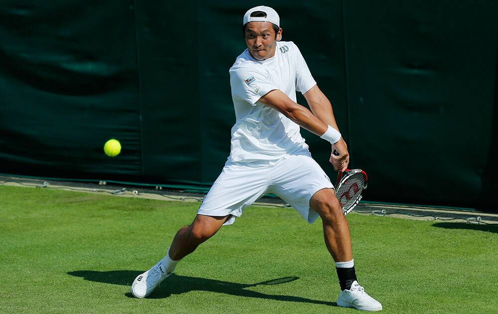 Tatsuma Ito of Japan plays a return to Simone Bolelli of Italy during their first round match at the All England Lawn Tennis Championships in Wimbledon.