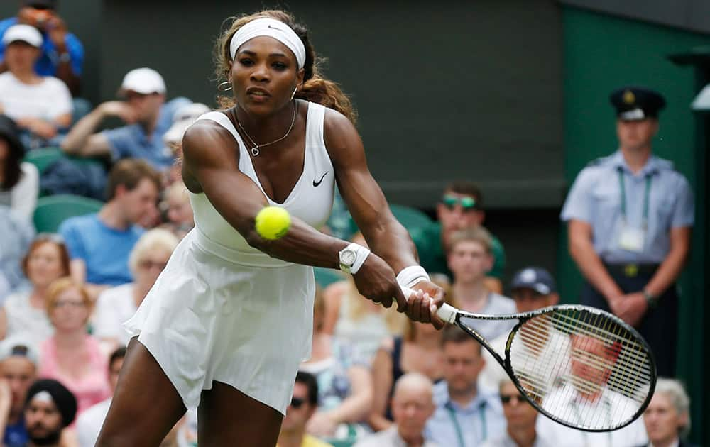 Serena Williams of US plays a return to Anna Tatishvili of US during their first round match at the All England Lawn Tennis Championships in Wimbledon, London.