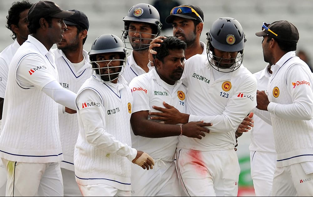 Sri Lanka's Rangana Herath, centre, is congratulated by teammates after getting England's Chris Jordan LBW for 21, during day five of the Second Test Match between England and Sri Lanka at Headingley cricket ground, Leeds, England.