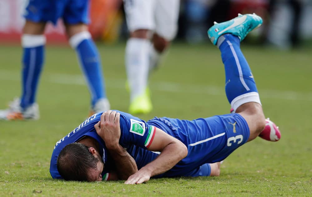 Italy's Giorgio Chiellini holds his shoulder after Uruguay's Luis Suarez ran into it with his teeth during the group D World Cup soccer match between Italy and Uruguay at the Arena das Dunas in Natal, Brazil.