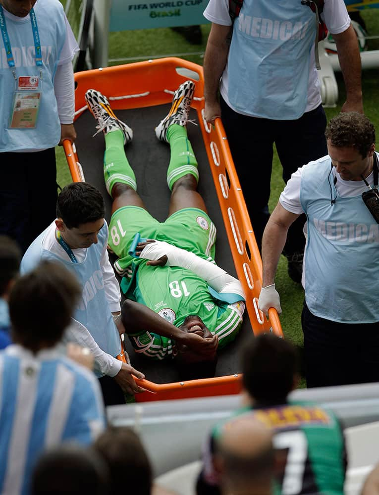 Nigeria's Michael Babatunde is taken from the pitch during the group F World Cup soccer match between Nigeria and Argentina at the Estadio Beira-Rio in Porto Alegre, Brazil.