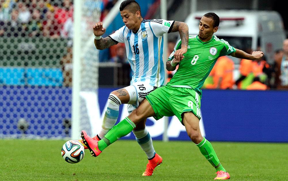 Argentina's Marcos Rojo, left, is challenged by Nigeria's Peter Odemwingie during the group F World Cup soccer match between Nigeria and Argentina at the Estadio Beira-Rio in Porto Alegre, Brazil.