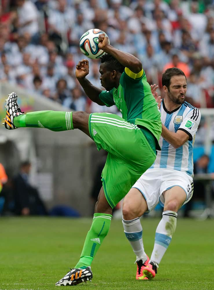 Nigeria's Joseph Yobo, left, and Argentina's Gonzalo Higuain challenge for the ball during the group F World Cup soccer match between Nigeria and Argentina at the Estadio Beira-Rio in Porto Alegre, Brazil.