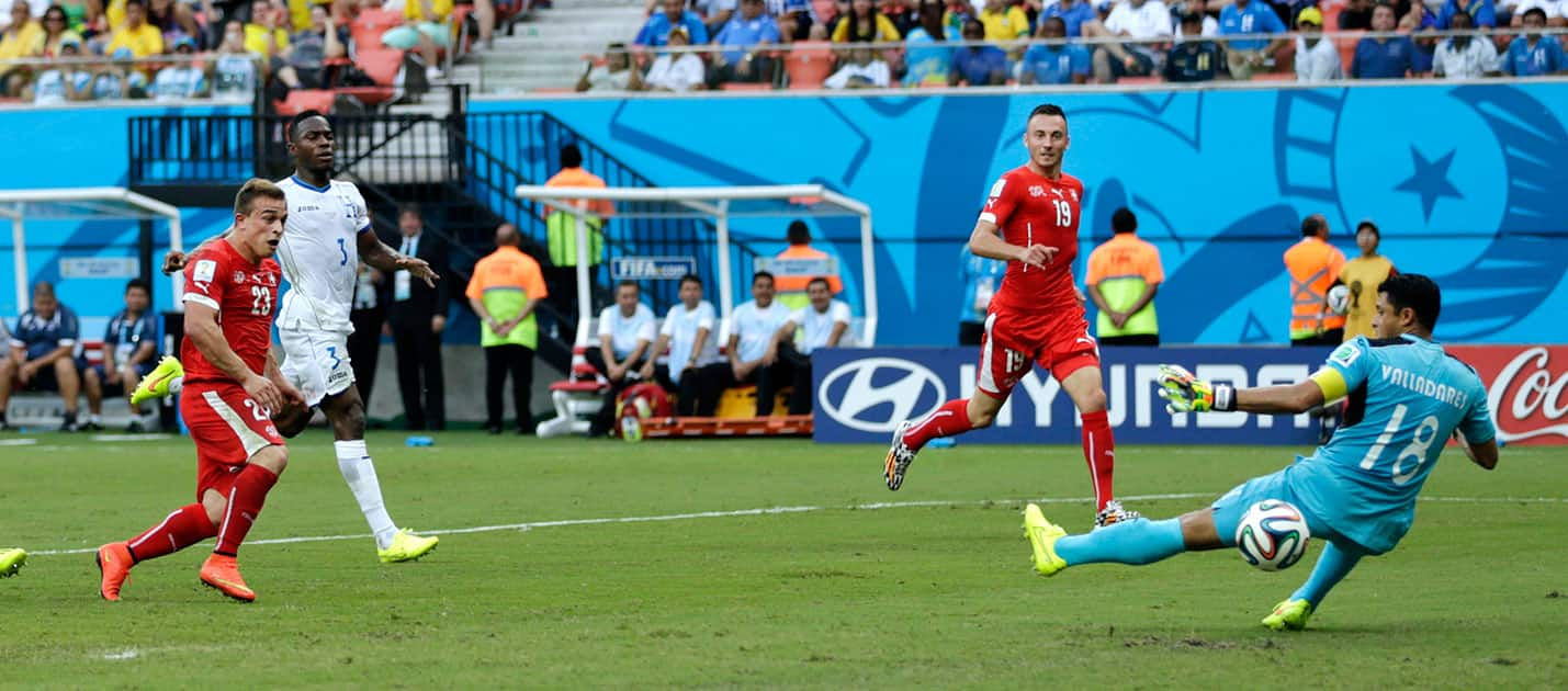 Switzerland's Xherdan Shaqiri, left, scores his team's second goal past Honduras' goalkeeper Noel Valladares (18) during the group E World Cup soccer match between Honduras and Switzerland at the Arena da Amazonia in Manaus, Brazil.