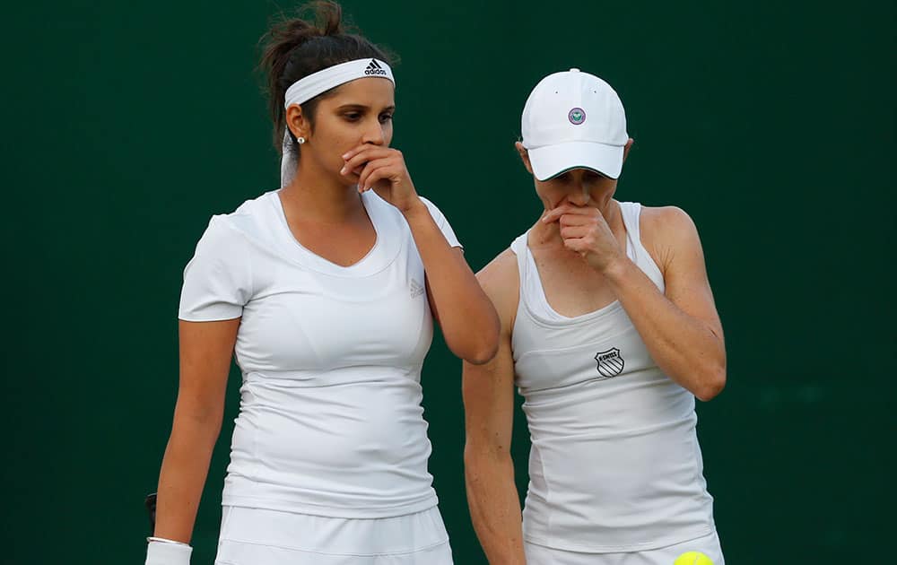 Sania Mizra  and playing partner Carla Black of Zimbabwe talk tactics as they play against Martina Hingis of Switzerland, and Vera Zonareva of Russia during the women's doubles match at the All England Lawn Tennis Championships in Wimbledon.