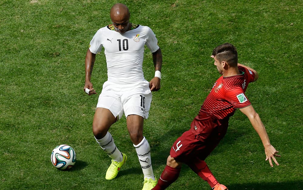 Ghana's Andre Ayew, left, and Portugal's Miguel Veloso battle for the ball during the group G World Cup soccer match between Portugal and Ghana at the Estadio Nacional in Brasilia, Brazil.