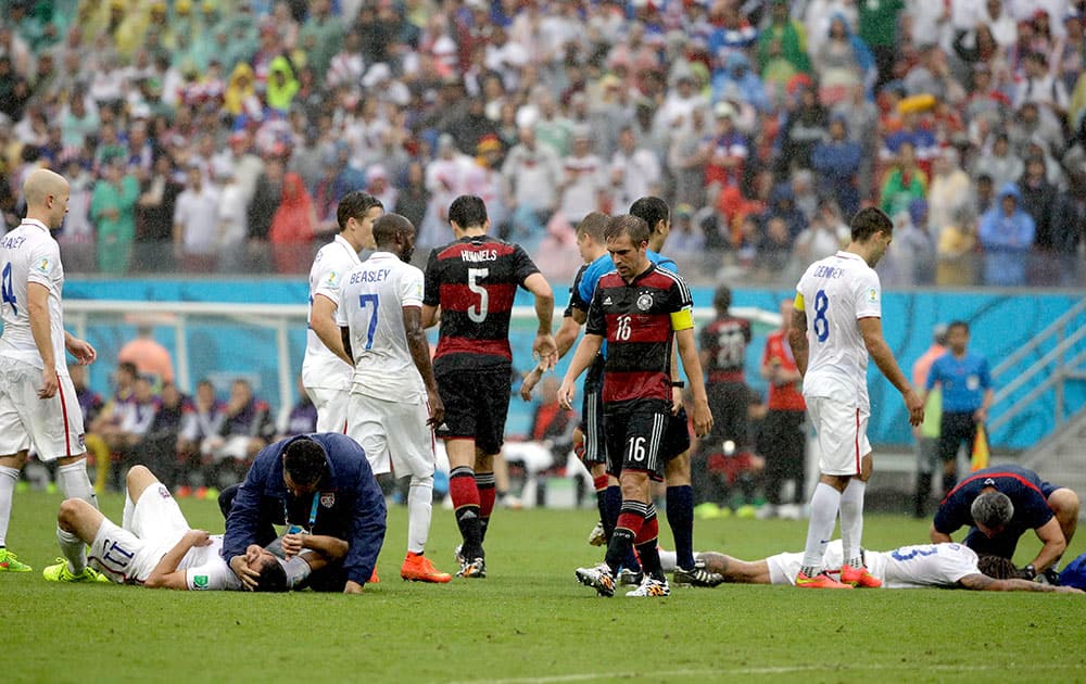 United States' Alejandro Bedoya, left, and United States' Jermaine Jones lie on the pitch after colliding during the group G World Cup soccer match between the USA and Germany at the Arena Pernambuco in Recife, Brazil.