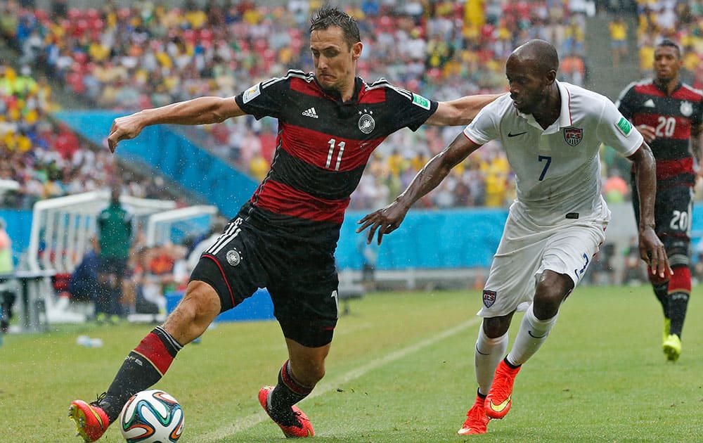 Germany's Miroslav Klose, left, and United States' DaMarcus Beasley challenge for the ball during the group G World Cup soccer match between the USA and Germany at the Arena Pernambuco in Recife, Brazil.